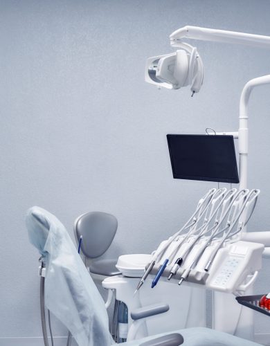 Professional medical equipment for dental procedures View from side of professional medical equipment and tools for dental procedures. White devices, modern devices and comfortable seat in dentist office in clinic. Concept of stomatology.